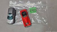 Top view of both die-cast cars in bag