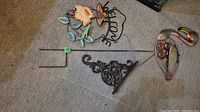 Lot overview showing stake rods, wall bracket, hanging sign, flamingo decor