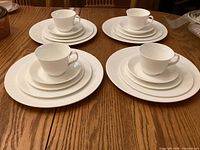 Four complete place settings displayed on table