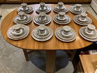 All 12 plated place settings with cups displayed on table