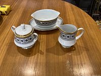 Creamer, covered sugar bowl, gravy boat on table