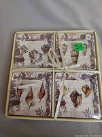 Boxed set of four seashell coasters tied with ribbon