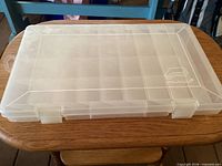 Closed Plano clear plastic tackle box on table