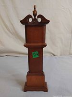 front view of wooden pocket watch hanger showing shelf, crest, base