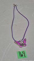 Full view of purple cord necklace with butterfly pendant