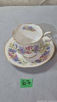 Teacup on saucer showing floral motif and gold trim