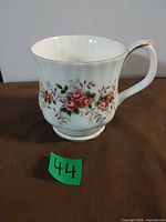 Full view of mug showing floral pattern, fluted shape and gold trim