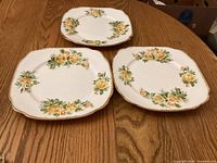 Three Royal Albert Tea Rose dinner plates displayed face up showing pattern and gold rim