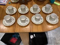 Top view of all eight cup and saucer sets on table