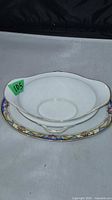 gravy boat resting on matching underplate showing top design and border