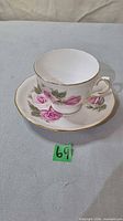 Cup on saucer showing floral pattern and gold rim