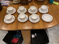 All seven cups and eight saucers arranged on table