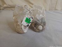 Two drawstring plastic bags filled with assorted seashells