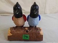 Front view showing both birds on log base