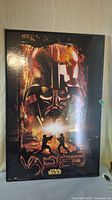 Full view of framed Star Wars Darth Vader lightsaber duel poster upright