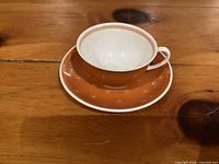 Cup resting on saucer showing exterior color and pattern