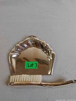 Front view of silver-plated crumb pan and whisk