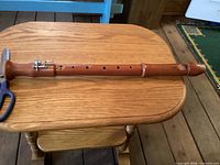 Full view of wooden tenor recorder front side showing finger holes and metal key
