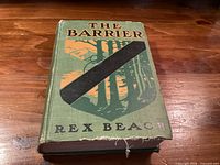 Front cover showing title, author, decorative design, and cloth fray at bottom