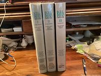 Spines of the three hardcover volumes standing together