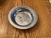 Top view of metal bowl showing engravings of quintuplets and names