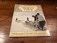 Front cover of souvenir booklet showing title and sled photo