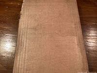 Front cover shows tan cloth and embossed coat of arms