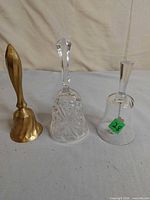 Group shot of three bells: brass, cut crystal, plain glass