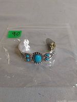 Top view of silver-tone cuff bracelet showing turquoise stones and design