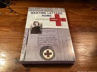 Front cover of sealed paperback showing title, author, Red Cross graphic