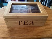 wood tea caddy closed showing TEA lettering and glass top