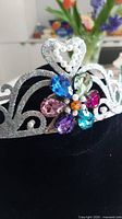 Full view of silver glitter tiara on stand