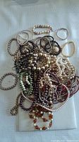 Pile of assorted faux-pearl necklaces and bracelets in various colours