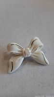 Front view of white porcelain bow pin