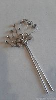 Front view of silver-tone crystal floral hairpin