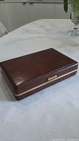 Closed brown vinyl jewellery box with gold trim