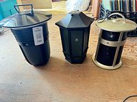 Three different Acoustic Research wireless speakers: black bucket style, black lantern style, beige cylindrical