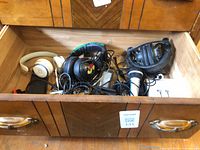 Drawer containing Beats headphones, gaming headset, black headphones, microphone and cables