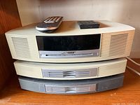 Front view of Bose Wave Music System stacked on multi-CD changer with remote on top