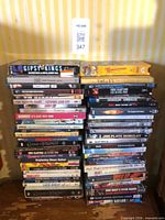 Two stacks of DVDs and VHS tapes on wooden surface