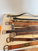 Belts laid out side by side showing buckles and ends