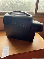 Left side view showing overall projector body and lens cap area