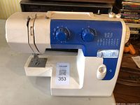 Front view showing stitch selector dials, bobbin compartment, and overall style