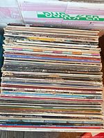 Stack of numerous vinyl LP records in sleeves