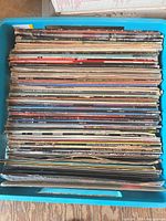 Top view of stacked vinyl records in blue crate