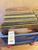 Crate containing stack of vinyl LPs, front album Jackson Browne Running On Empty visible