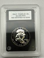 Obverse view of slabbed 1962-P Franklin half dollar showing grade label