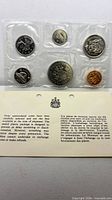 Front of sealed 6-coin set with bilingual information card