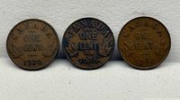 Group view of three Canadian one-cent coins dated 1920, 1936, 1933