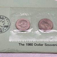 Souvenir set card showing two of the three encapsulated coins